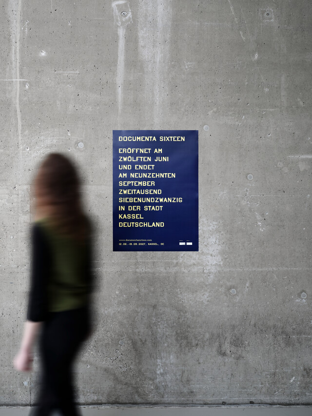 A woman is passing the D16 poster